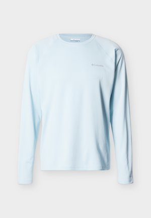 Svetlomodrá dlhá blúzka Columbia s okrúhlym výstrihom a jemným logom na ľavej strane hrudníka, zobrazená spredu na jednoduchom pozadí.