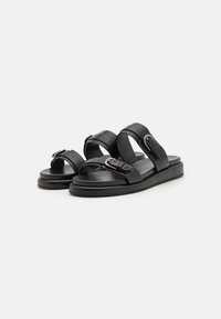 Zwarte leren sandalen met twee brede banden en gespen. Platte zool met een gematteerde voetbed, biedt een minimalistisch ontwerp.