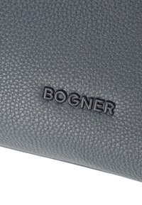 Borsa in pelle grigia a buccia di mela con logo "BOGNER" in rilievo. Superficie testurizzata con una leggera lucentezza, forma rettangolare e bordi lisci.