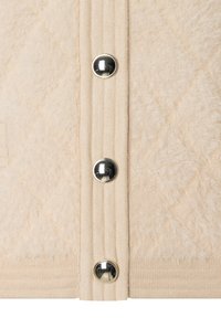 Beige gesteppter Pullover mit weicher, fuzzy Textur, metallischen Knöpfen und geripptem Stoffpanel an der Vorderseite für zusätzlichen Detail.