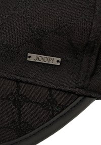 Black cap with textured fabric featuring a subtle pattern, metal tag with "JOOP!" branding, and smooth black accents along the brim.