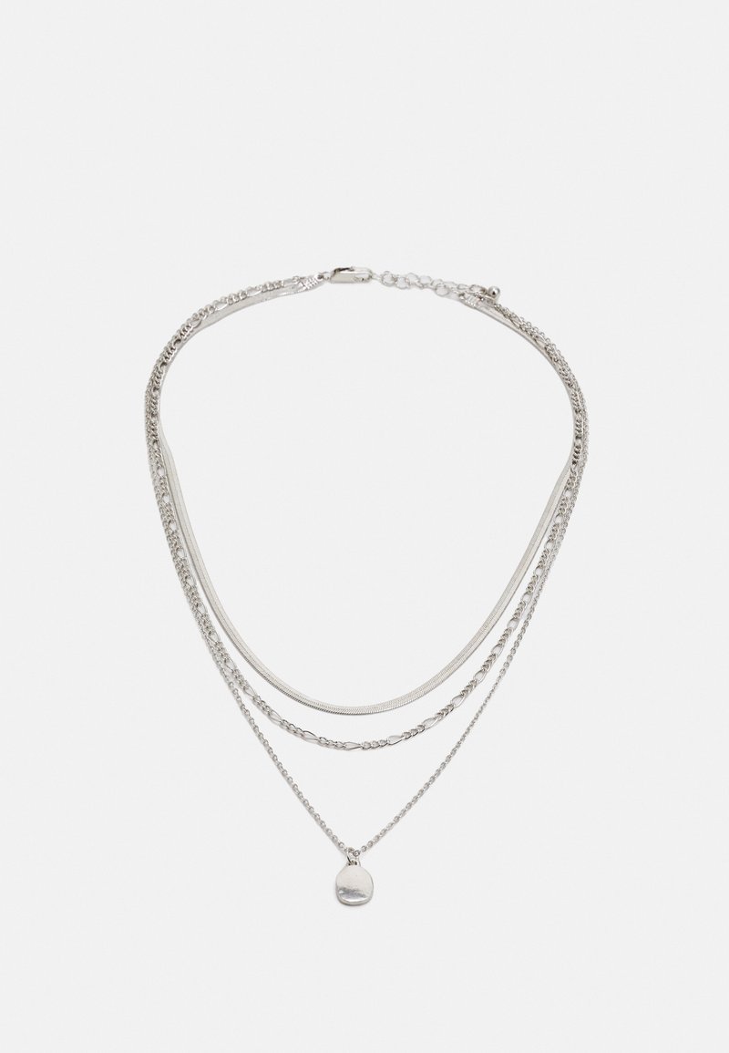 Silberne, mehrschichtige Halskette mit verschiedenen Kettenstilen, darunter eine glatte Kette und eine Perlenkette, mit einem kleinen runden Anhänger.