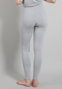 Grijze stretchleggings gemaakt van zachte stof, fitted vorm, gladde textuur en hoog taille ontwerp, zonder zichtbare patronen of hardware.