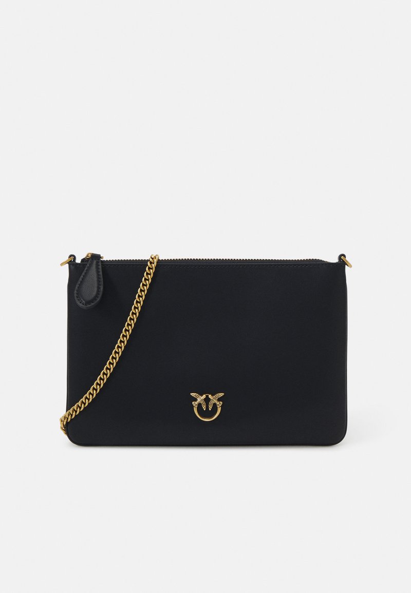 Bolso de mano negro, de textura lisa, con cadena dorada y cierre con cremallera. Presenta un prominente detalle del logotipo dorado en la parte frontal.