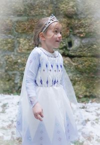 Costume dress in white with blue diamond patterns, sheer sleeves, and a silver tiara adorned with blue jewels. Tall, layered design.