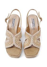 Sandali in pelle intrecciata beige con tacco a zeppa, punta aperta e cinturino alla caviglia. Presentano un motivo testurizzato e una soletta imbottita.