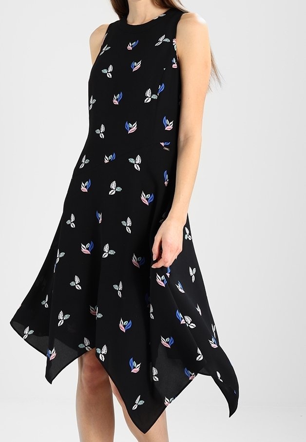 Vestido negro sin mangas con un dobladillo acampanado, que presenta coloridos patrones florales en azul, rosa y blanco sobre una tela suave.