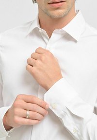 Vit skjorta med knappar, tillverkad av mjukt tyg. Har klassisk krage och pärlknappar på manschetterna. Figursydd design med en ren finish.