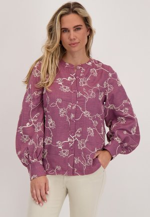 Paarse blouse met knopen, versierd met witte bloemenborduursels, lange opgeblazen mouwen en een ronde halslijn, gemaakt van lichtgewicht stof.