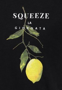 gele citroen met groene bladeren die aan een tak hangen tegen een zwarte achtergrond met witte tekst "Squeeze la Giornata."