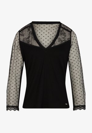 Haut noir avec un col en V, des manches longues en maille transparente à pois noirs et des finitions en dentelle au niveau des poignets. Tissu du corps côtelé.