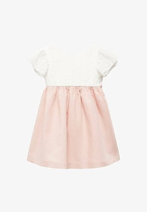 Weißes Baumwolloberteil mit strukturierter Detailverarbeitung, kurzen, gerafften Ärmeln; rosa Leinenrock mit Taillierung, knielang.