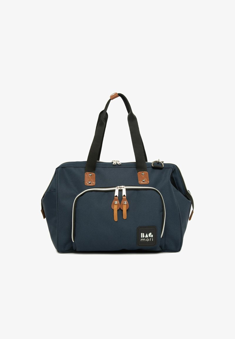 Sac en tissu bleu marine avec des accents en cuir marron, deux poignées sur le dessus, fermeture éclair et poche avant avec un logo et un passepoil contrastant.