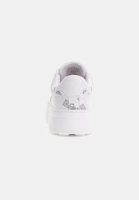 Sneaker bianco con suola spessa, caratterizzata da un marchio impresso e un sottile motivo grigio sul tallone. Texture in pelle liscia.