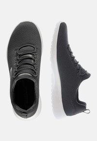 Zapatillas deportivas de malla gris con una suela blanca lisa, que presentan una punta redondeada, diseño de cordones y un discreto detalle de logo en el lateral.