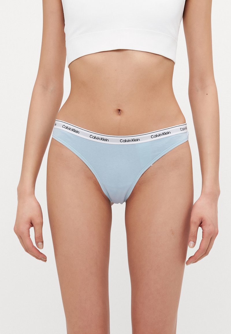 Lys blå bomullsunderbukser med en hvit kant som har "Calvin Klein"-logo. Glatt tekstur og lav midje-design.