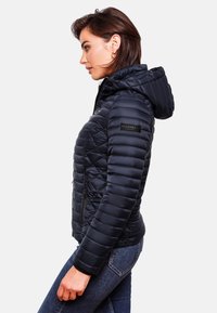 Navy padded jacket with a hood, featuring quilted sections, zippered pockets, and a side logo patch. Smooth fabric with a glossy finish.
