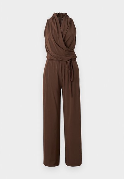 Combinaison marron sans manches avec col en V drapé, taille cintrée avec ceinture nouée et pantalon à jambes larges sur fond uni.