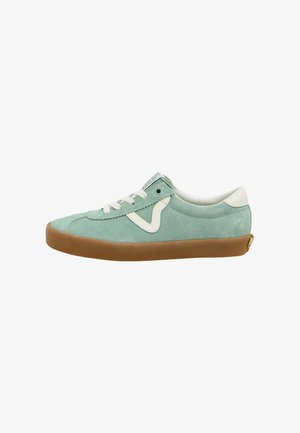 Zapatilla de ante verde claro con acentos en blanco, puntera redonda, cierre de cordones y suela de goma marrón. Presenta un diseño de logo en el lateral.