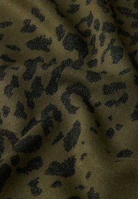 Tessuto verde scuro con motivo a macchie di leopardo nere e leggero effetto scintillante, che mostra una superficie strutturata e leggermente stropicciata.