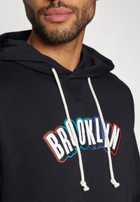 Nike Performance NBA CITY EDITION BROOKLYN NETS HOODY - Klubové oblečenie - black/white