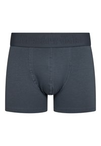 Tummanharmaat bokserit, jotka on valmistettu pehmeästä kankaasta. Niissä on vyötärö, jossa on kohollaan olevia brändimerkintöjä, ja muotoiltu pussi tukemista varten.