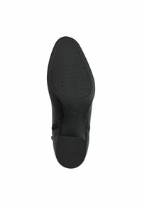 Semelle noire de chaussure avec un motif en diamant texturé, bout rond et détail de fermeture éclair sur le côté. Fabriquée en caoutchouc et matériaux synthétiques.