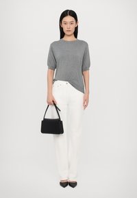 Grå kortermet skjorte, hvite vide bukser og svart håndveske. Svarte spisse sko. Jevn tekstur, uformell design. Minimaal aksent.