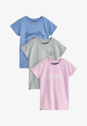 Tre T-shirts med korte ærmer i blå, grå og pink, hver med Superdry mærketekst og logoer foran.