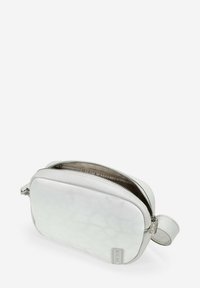 Bolso de cuero blanco con una superficie texturizada, cierre de cremallera y una asa lateral. Presenta un forro interior suave y un branding sutil.