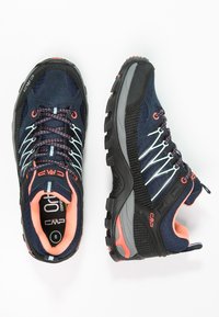 Granatowe buty sportowe z czarnymi akcentami, siateczkowa cholewka, różowe sznurówki i fakturowana gumowa podeszwa zapewniająca przyczepność. Posiadają wyściółkę amortyzującą.