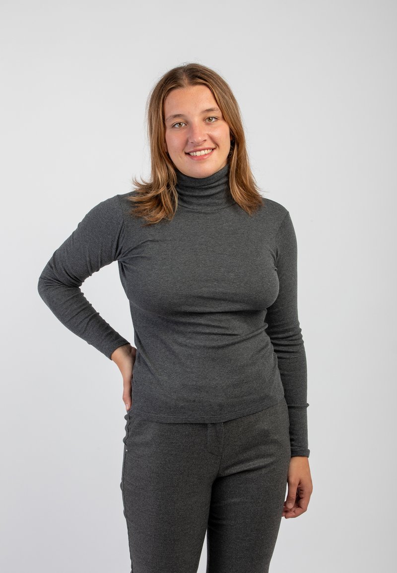Maglione a collo alto grigio, aderente, con maniche lunghe, realizzato in un tessuto morbido e elastico. Abbinato a pantaloni grigi a vestibilità slim. Design semplice.