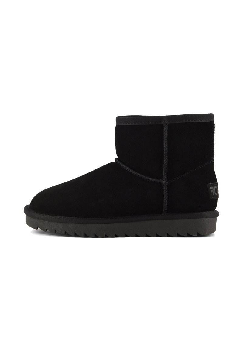 Stivale alla caviglia in suede nero con punta rotonda, dettagli cuciti e suola in gomma testurizzata con un motivo a zigzag.