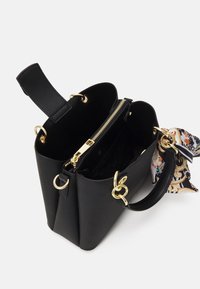Black textured leather handbag with gold hardware, featuring a zippered pocket, dual handles, and a decorative printed scarf accent.
