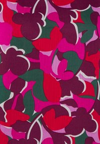 Tissu floral coloré présentant des formes vibrantes en rose, rouge et violet sur un fond vert foncé avec des contours blancs et une surface texturée.