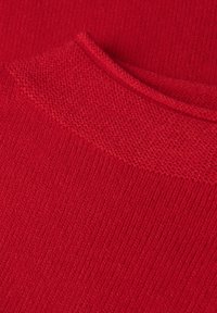 Tessuto a maglia rosso che mostra un design testurizzato con accenti a coste sul colletto e una superficie del corpo liscia.
