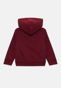 Felpa bordeaux con tessuto testurizzato, tasca a marsupio e polsini a costine. Presenta un cappuccio con coulisse e retro semplice.