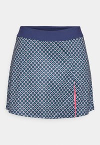 Jupe bleu marine avec un petit motif floral blanc et rouge, taille large en bleu marine uni, et une fente sur le côté avec une bordure rose.
