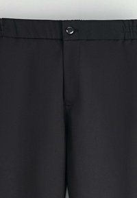 Pantalons noirs avec une texture lisse et mate, dotés d'une fermeture à bouton à l'avant et d'une taille élastique pour un confort accru.