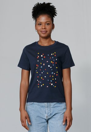 T-shirt en coton marine avec un motif dispersé de formes abstraites colorées en rouge, jaune, bleu et blanc sur le devant.