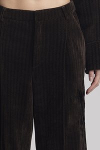 Hnědé kordové kalhoty s vertikálními pruhy, vysokým pasem a předními kapsami. Měkká textura s mírně volným střihem.