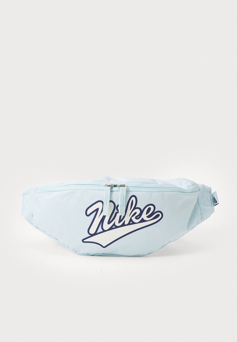 Bolsa de cintura azul-claro feita de tecido durável, apresentando um proeminente logótipo da "Nike" em azul-marinho. Possui um fecho com zíper e uma alça ajustável.