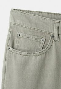 Jean en denim gris clair montrant la poche avant avec rivets, passant de ceinture et double surpiqûre visible sur le tissu.