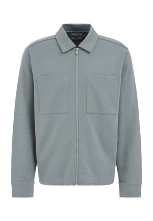 Chaqueta gris con cremallera en un tejido texturizado con cuello, dos bolsillos frontales y puños acanalados, con un sutil patrón de espina de pescado.