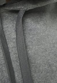 Sudadera con capucha gris de textura suave, con cuerda de ajuste y acentos acanalados cerca del cuello y los puños.