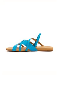 Türkise flache Sandalen mit mehreren gekreuzten Riemen, ausgestattet mit einem glatten synthetischen Obermaterial und einer tanfarbenen gepolsterten Sohle.