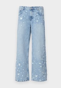 Jeans de pata de elefante de color azul claro con un acabado desgastado y bordes deshilachados, que presentan roturas dispersas y una silueta relajada. Fabricados en material de mezclilla.