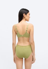 Zielony oliwkowy komplet biustonosza i majtek z wysokim stanem wykonany z miękkiego materiału. Regulowane ramiączka i koronkowa lamówka na pasku dodają dodatkowych detali.