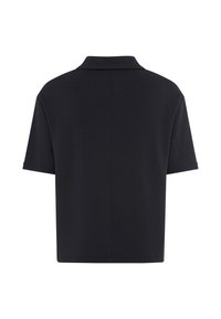 Polo noir à manches courtes vu de dos, avec une couture droite au centre et un col classique.