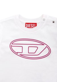 Witte katoenen T-shirt met een groot roze ovaal logo ontwerp. De halslijn heeft drukknoopjes voor een functionele accent.